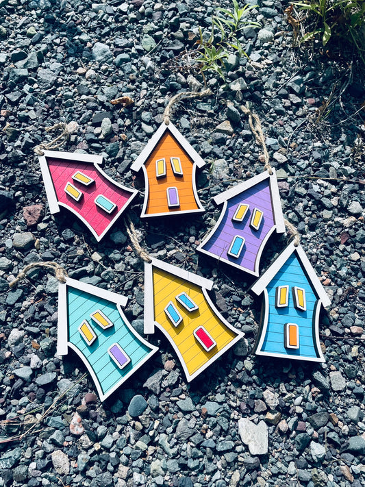 Six colorful Newfoundland Jellybean Row House wooden ornaments displayed together outdoors